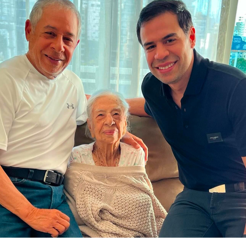 Tres personas sonrientes en sofá