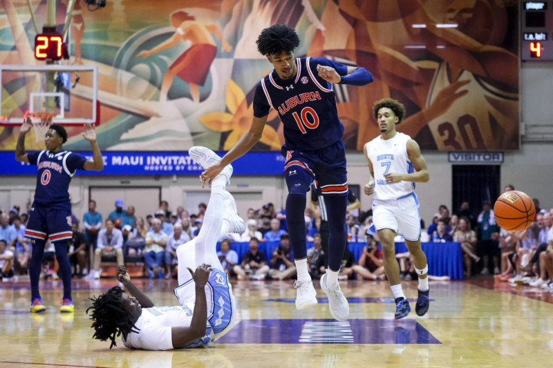 Jugador salta sobre rival en baloncesto