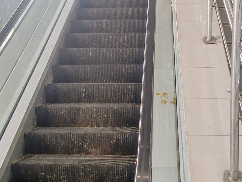 Escalera mecánica sucia y deteriorada