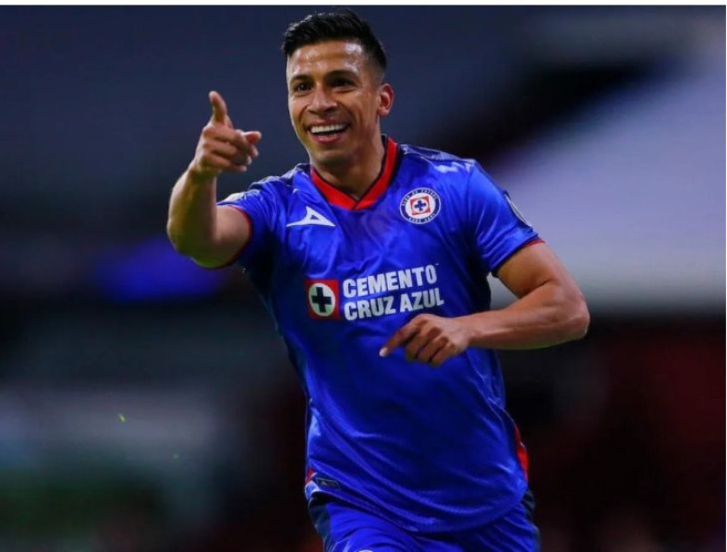 Futbolista señalando en uniforme azul