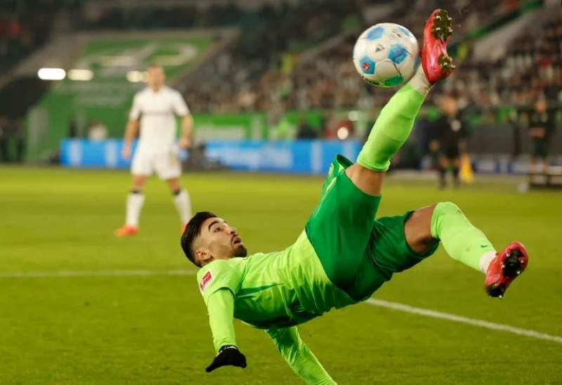 Futbolista pateando balón en salto