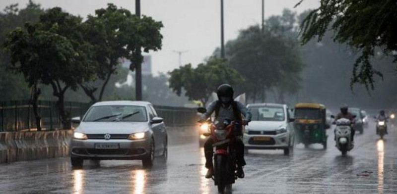 Vehículos bajo lluvia en calle urbana