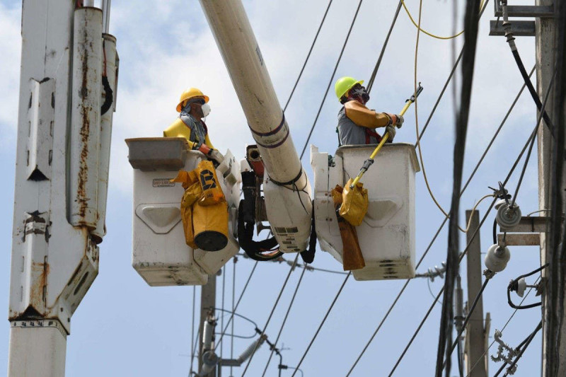 Técnicos en camiones con canastas elevadoras