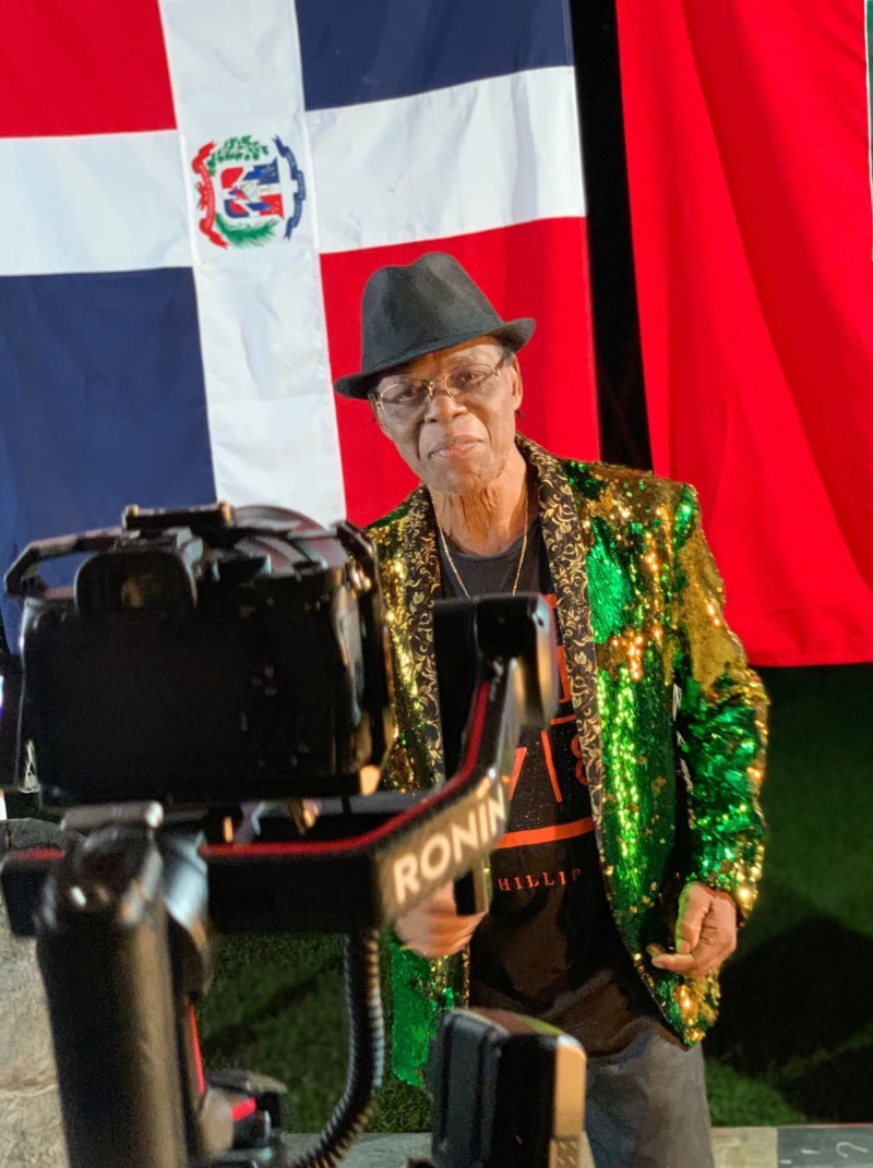 Hombre con chaqueta verde y bandera dominicana