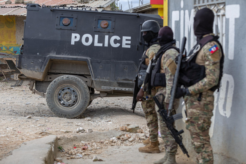 Policías armados junto a patrulla