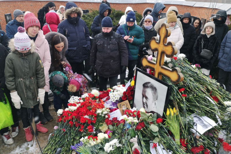 Personas reunidas ante monumento memorial