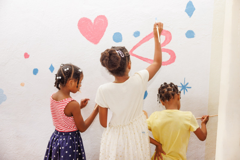 Niños pintando una pared blanca