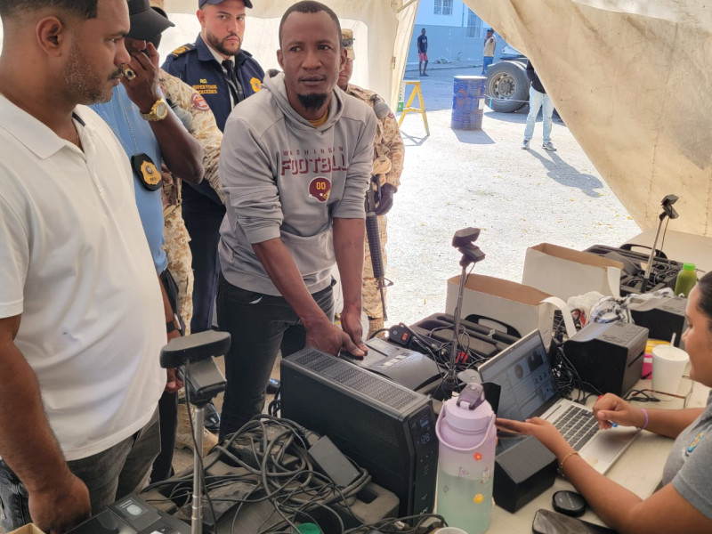 Hombre reparando electrónicos con camisa gris