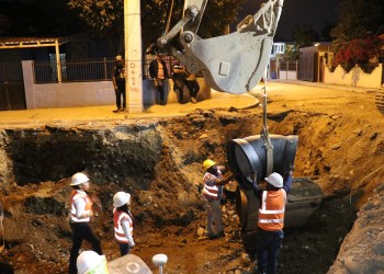 Trabajadores excavando en obra nocturna