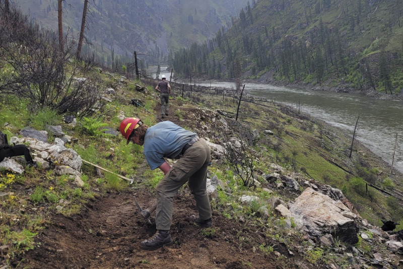 Hombre excavando en sendero montañoso