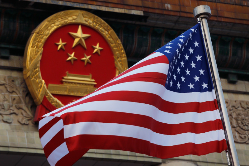 Bandera estadounidense ante emblema chino