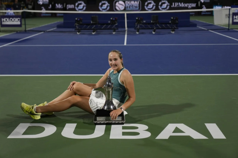 Tenista celebra con trofeo.