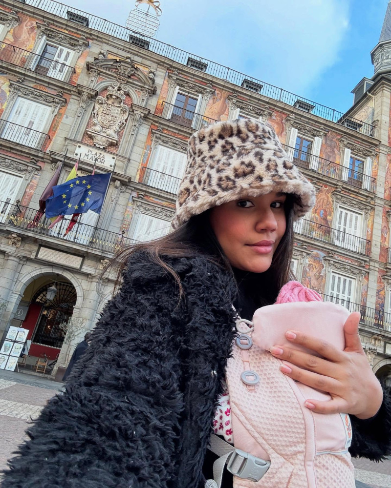 Mujer carga bebé en portabebé rosa