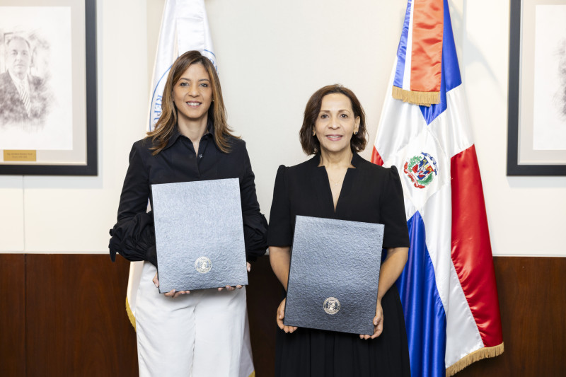 Dos graduadas con diplomas universitarios posando