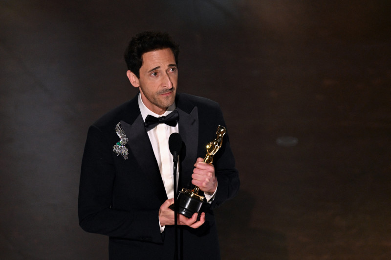 Hombre con smoking sostiene premio Oscar