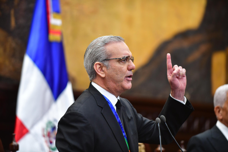 Hombre habla frente bandera dominicana