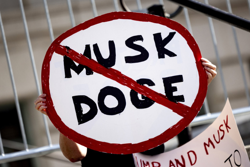 Cartel de protesta con "Musk Doge"